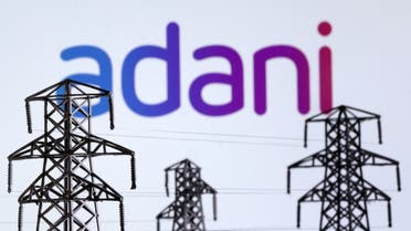 Electric power transmission pylon miniatures and Adani Green Energy logo are seen in this illustration taken, December 9, 2022. (Reuters)