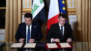 French President Emmanuel Macron and Iraq's Prime Minister Mohammed al-Sudani sign documents at the Elysee Presidential Palace, in Paris, France, January 26, 2023. (Reuters)