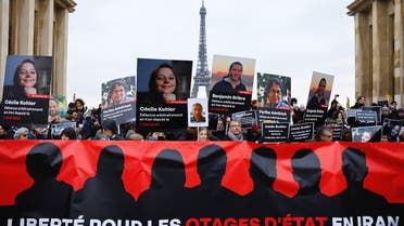 Supporters and relatives of French citizens detained in Iran, Cecile Kohler, Benjamin Briere, Jacques Paris and Fariba Adelkhah, gather in front of the Eiffel Tower, during a rally demanding their release, in Paris, France, January 28, 2023. (Reuters)