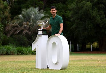 Serbia's Novak Djokovic poses with the trophy as he celebrates winning his tenth Australian Open. (Reuters)