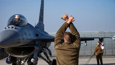 A US Air Force airman marshals an F-16 Fighting Falcon aircraft near Fetesti, Romania, February 17, 2022. (Reuters)