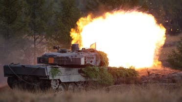 A Leopard 2 main battle tank of the German armed forces Bundeswehr shoots during a visit by the German Chancellor of the troops during a training exercise at the military ground in Ostenholz, northern Germany, on October 17, 2022. (AFP)