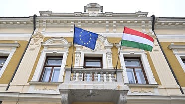 The EU and the Hungarian flag flutter in the wind on a balcony of an historical house in Veszprem on January 21, 2023. (AFP)