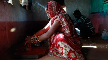 Krishna, 13, grinds spices inside the kitchen at her house in a village near Baran, located in the northwestern state of Rajasthan, July 17, 2012. Krishna married her husband Gopal when she was 11 and he was 13. (File photo: Reuters)