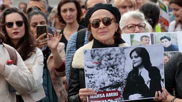 A woman holds a poster of Iranian Mahsa Amini during a rally in support of the demonstrations in Iran, at The Place de la Republique in Paris, on October 29, 2022. (AFP)