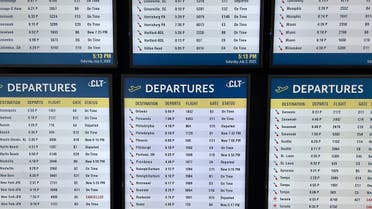 Screens display flight departure schedules at Charlotte Douglas International Airport (CLT) in Charlotte, North Carolina, on July 2, 2022. (AFP)