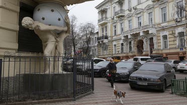 A woman walks with a dog next to a building in the historical city center, amid Russia’s attack on Ukraine, in Odesa, Ukraine on January 25, 2023. (Reuters)