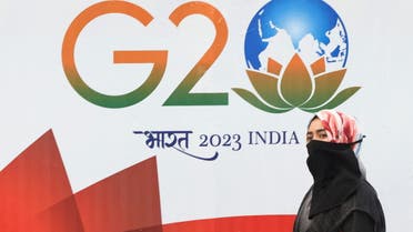 A woman walks past a hoarding of India's G20 presidency, on a street in Mumbai, India, December 15, 2022. (Reuters)