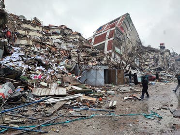 People stand in front of collapsed buildings following an earthquake in Kahramanmaras, Turkey February 6, 2023. (Reuters)