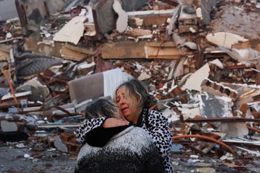 A woman reacts while embracing another person, near rubble following an earthquake in Hatay, Turkey, February 7, 2023. (Reuters)