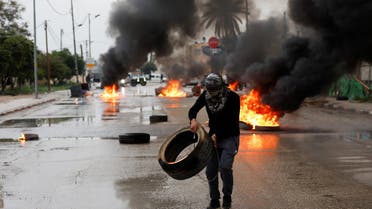 PREVIEW XML A Palestinian man carries a tyre during clashes with Israeli troops during a military raid in Jericho, in the Israeli-occupied West Bank, February 4, 2023. (Reuters)