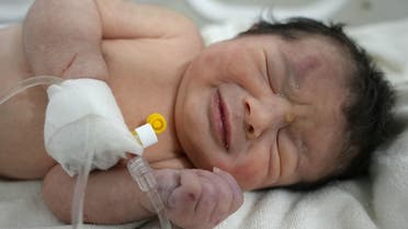 A newborn baby who was found still tied by her umbilical cord to her mother and pulled alive from the rubble of a home in northern Syria following a deadly earthquake, receives medical care. (AFP)