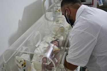 A newborn baby who was found still tied by her umbilical cord to her mother and pulled alive from the rubble of a home in northern Syria following a deadly earthquake, receives medical care. (AFP)