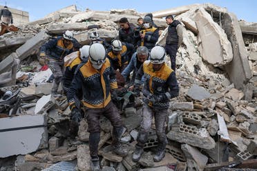 Members of the Syrian civil defense, known as the White Helmets, transport a casualty from the rubble of buildings in the village of Azmarin in Syria’s rebel-held northwestern Idlib province at the border with Turkey following an earthquake, on February 7, 2023. (AFP)