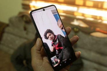 حافظ ناصر الوكاع حاملا هاتفه