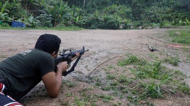 Sithu Maung, an elected member of parliament in the 2020 election, aims a gun at a training camp in an area controlled by ethnic Karen rebels, Karen State, Myanmar, September 12, 2021. (Reuters)