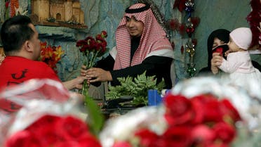 A Saudi man buys red roses for his wife at a flower shop in Riyadh on the eve of Valentine's Day. (File photo: AFP)