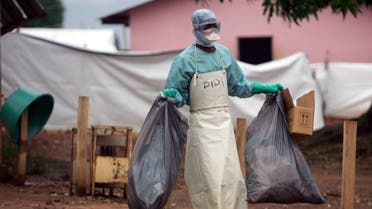 A health worker in protective clothing carries waste for disposal outside the isolation ward where victims of the deadly Marburg virus are treated in the northern Angolan town of Uige, April 20, 2005. (Reuters)