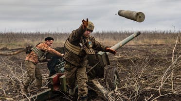 A Ukrainian serviceman of an artillery unit throws an empty shell as they fire towards Russian positions on the outskirts of Bakhmut, eastern Ukraine on December 30, 2022. (AFP)