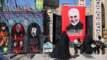 People visit the grave of senior Iranian military commander General Qassem Soleimani (pictured in poster) during the one year anniversary of his killing in a US attack, at his hometown of Kerman, Iran onJanuary 2, 2021. (West Asia News Agency via Reuters)