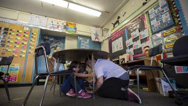 A teacher and students practice the drop, cover, and hold on technique during the Great ShakeOut earthquake drill at Marlton School in Los Angeles, California October 15, 2015. (Reuters)