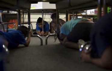 A teacher instructs students during the drop, cover, and hold on technique during the Great ShakeOut earthquake drill at Marlton School for the Deaf in Los Angeles, California October 15, 2015. (Reuters)
