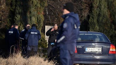 Security officials gather on the outskirts of the village of Lokorsko, some 20 kilometres (12 miles) north-east of Sofia, after the discovery of eighteen dead migrants in the rear of an abandoned truck. (AFP)