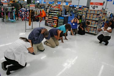 Walmart employees practice the drop, cover, and hold on technique during the Great ShakeOut earthquake drill at Walmart in Torrance, California October 17, 2013. (Reuters)