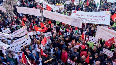 Protesters lift banners during a demonstration called by the General Union of Tunisian Workers (UGTT) over worsening economic woes and the arrest of a top union official, in Tunisia's second city of Sfax, on February 18, 2023. (AFP)