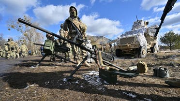 An M2 Browning .50 caliber machine gun and a Mk 19 grenade launcher sit on the ground as Ukrainian soldiers take part in military drills simulating a possible attack in the Chernobyl zone a few kilometers from the border with Belarus, on February 20, 2023. (AFP)            