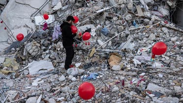 Ogun Sever Okur, 38-year-old Turkish man inflates balloons on the debris of a collapsed building in Antakya, southern Turkey on February 21, 2023. (AFP)