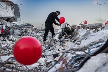 Ogun Sever Okur, 38-year-old Turkish man inflates balloons on the debris of a collapsed building in Antakya, southern Turkey on February 21, 2023. (AFP)