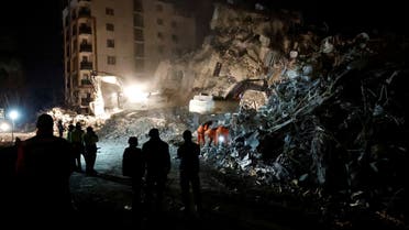 People wait as emergency workers search through rubble for the bodies of a mother and child, in the aftermath of a deadly earthquake, in Antakya, Hatay province, Turkey, February 21 2023. (Reuters)