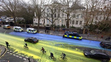 Police officers respond, after Protest group 'Led by Donkeys' spread paint in the colours of the Ukrainian flag on the road, ahead of the first anniversary of Russia's invasion of Ukraine, outside the Russian Embassy in London, Britain February 23, 2023. (Reuters)