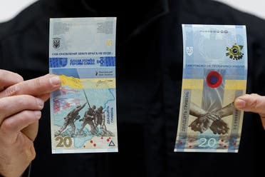 Governor of the National Bank of Ukraine Andriy Pyshnyi holds banknotes dedicated to the first anniversary of Russia’s invasion on Ukraine, during a presentation in Kyiv, Ukraine, on February 23, 2023. (Reuters) 