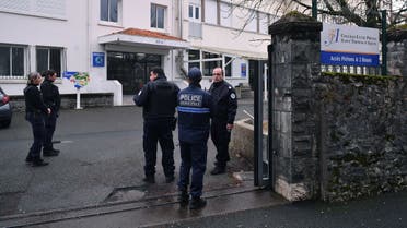 Police officers stand at the entrance of the Saint-Thomas d’Aquin middle school, where a teacher died after being stabbed by a pupil, in Saint-Jean-de-Luz, southwestern France, on February 22, 2023. (AFP)