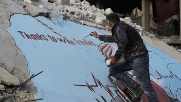 Syrian artist Aziz Asmar paints a street art on the rubble of damaged buildings in the aftermath of a deadly earthquake, in Jandaris, Syria February 22, 2023. (Reuters)