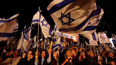 People hold Israeli flags as they attend a protest against Israel's Prime Minister Benjamin Netanyahu's new right-wing coalition and its proposed judicial changes to reduce powers of the Supreme Court in Tel Aviv, Israel February 25, 2023. (Reuters)