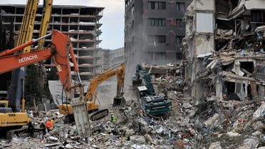 Workers clean the rubble of a collapsed building in the aftermath of a deadly earthquake in Antakya, Hatay province, Turkey, February 21, 2023. REUTERS/Thaier Al-Sudani