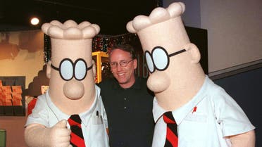 Scott Adams, the creator of Dilbert, the cartoon character that lampoons the absurdities of corporate life, poses with two Dilbert characters at a party January 8, 1999 in Pasadena, Calif. REUTERS/Fred Prouser/File Photo