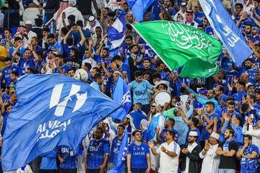 Hilal's fans cheer for their team with the flag of the club and of Saudi Arabia during the AFC Champions League semi-final football match between al-Duhail and al-Hilal at al-Thumama Stadium in Doha on February 26, 2023. (AFP)