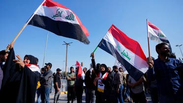 Protesters wave Iraqi flags during a protest against planned changes in electoral law, near Iraq's parliament in Baghdad, Iraq, Monday, Feb. 27, 2023. (AP)
