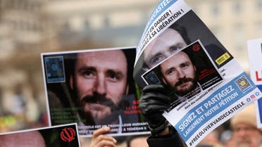 People hold pictures of Belgian aid worker Olivier Vandecasteele during a protest against his detention in Iran, as he was sentenced to 40 years in prison and 74 lashes on charges including spying, in Brussels, Belgium January 22, 2023. REUTERS/Yves Herman