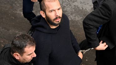 British-US influencer Andrew Tate arrives handcuffed and escorted by police at a courthouse in Bucharest on February 1, 2023 to hear the court decision on his appeal against pre-trial detention for alleged human trafficking, rape and forming a criminal group. (AFP)