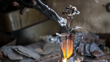 Viktor Mikhalev works in a workshop in his house in Donetsk, Russian-controlled Donetsk region, eastern Ukraine, Saturday, March 4, 2023. Mikhalev is transforming weapons and ammunition into flowers of war. (AP)