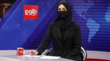 A female presenter for Tolo News, Khatereh Ahmadi, while covering her face, works in a newsroom at Tolo TV station in Kabul, Afghanistan, May 22, 2022. (Reuters)