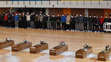 This photo obtained from Italian news agency Ansa and taken on March 1, 2023 shows relatives mourning and praying by coffins of 65 victims of a devastating migrant shipwreck off Italy's southern coast laid out in a sports hall of Crotone on March 01, 2023. (Stringer/ANSA/AFP/Italy Out)