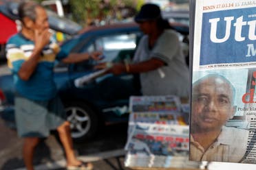 A front page picture of Zaharie Ahmad Shah, the pilot of the missing Malaysia Airlines MH370, is seen at a stand as a man buys newspapers in Dengkil, near Kuala Lumpur International Airport March 17, 2014. (File photo: Reuters)
