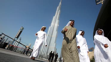 A group of Emiratis walk past the Burj Dubai Tower, the tallest tower in the world, on the day of its inauguration, in Dubai January 4, 2010. (Reuters)