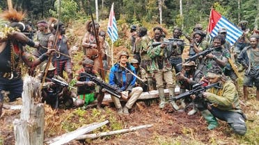 A man who is identified as Philip Mehrtens, the New Zealand pilot who is said to be held hostage by a pro-independence group, sits among the separatist fighters in Indonesia's Papua region, March 6, 2023. (The West Papua National Liberation Army (TPNPB)/Handout via Reuters) 